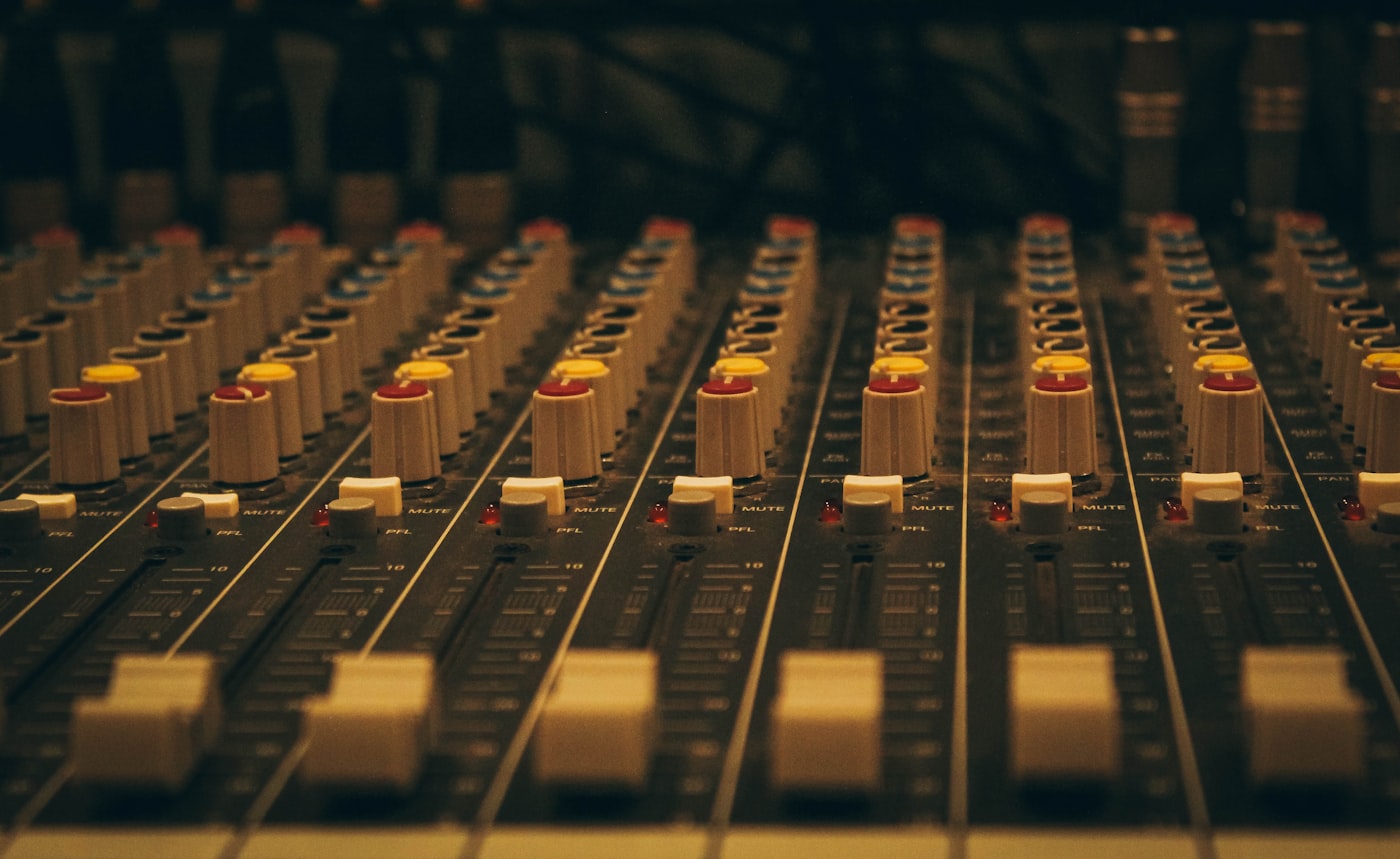 Close-up of mixing console faders in warm light