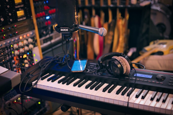 A studio corner with a MIDI keyboard, microphone and headphones